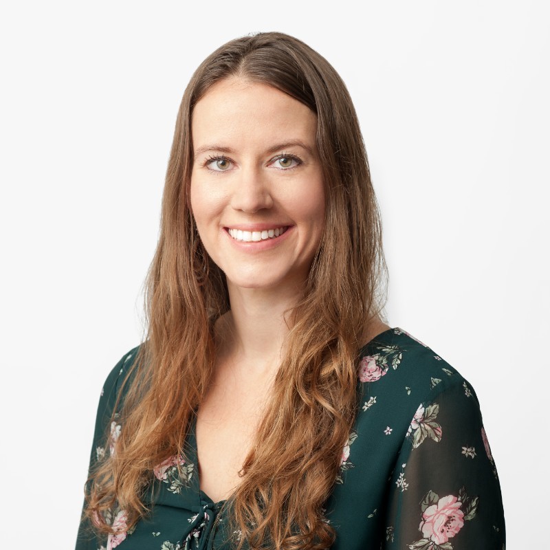 Kara Booker, smiling, in a dark green floral top